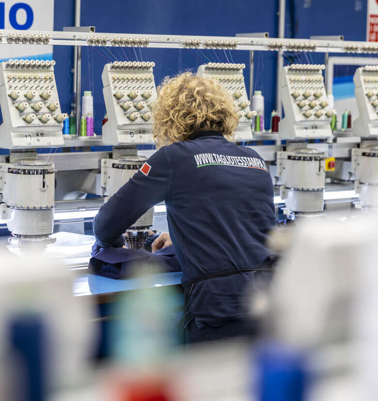 Un'operaia sta lavorando su una macchina da ricamo